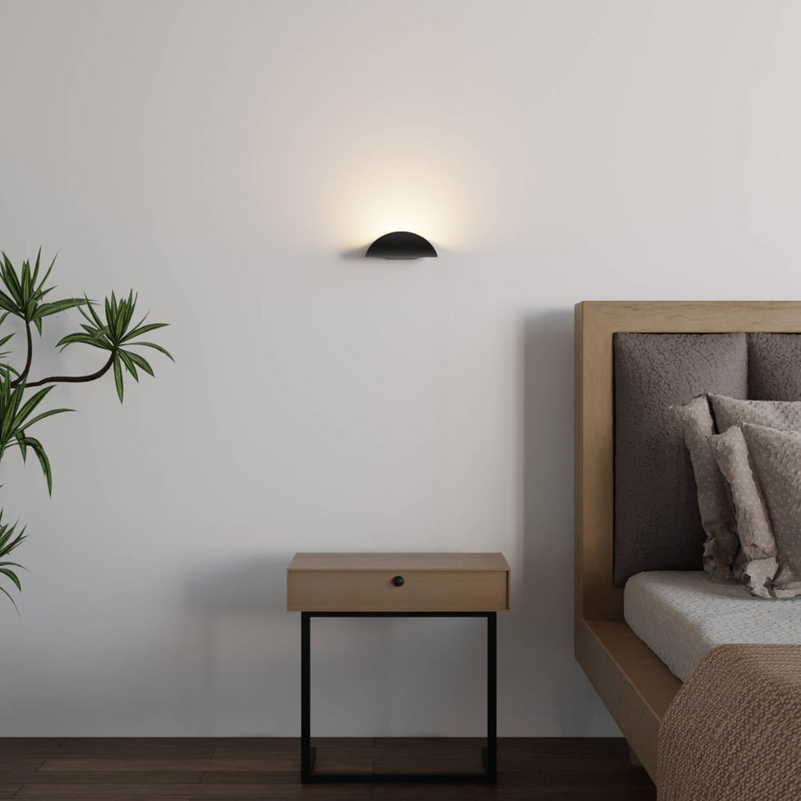 Halfronde wandlamp met licht omhoog langs de muur